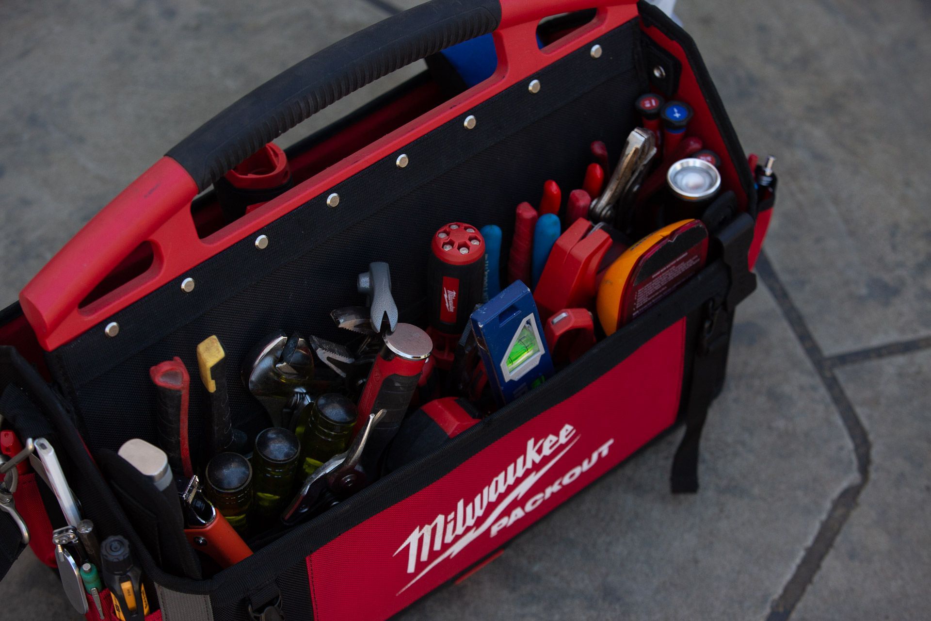 A red and black milwaukee toolbox filled with tools