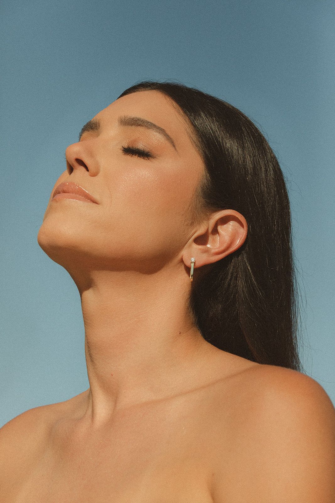 A woman is smiling with her hand on her face.