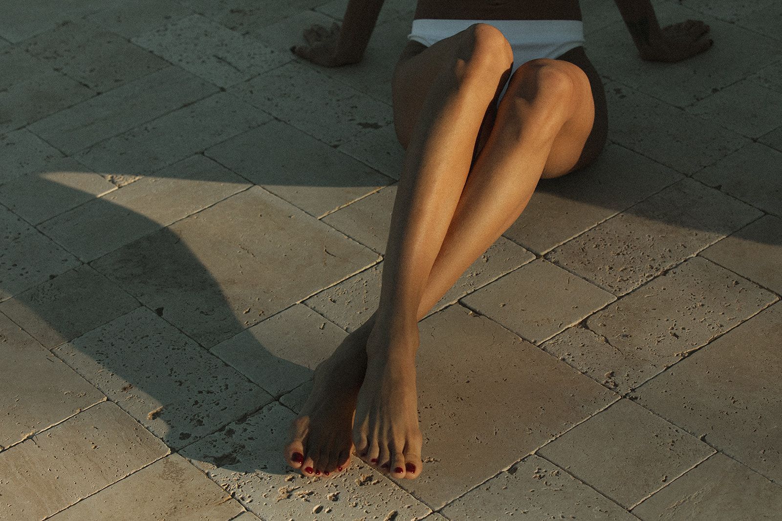 A woman sitting on the ground with her legs crossed