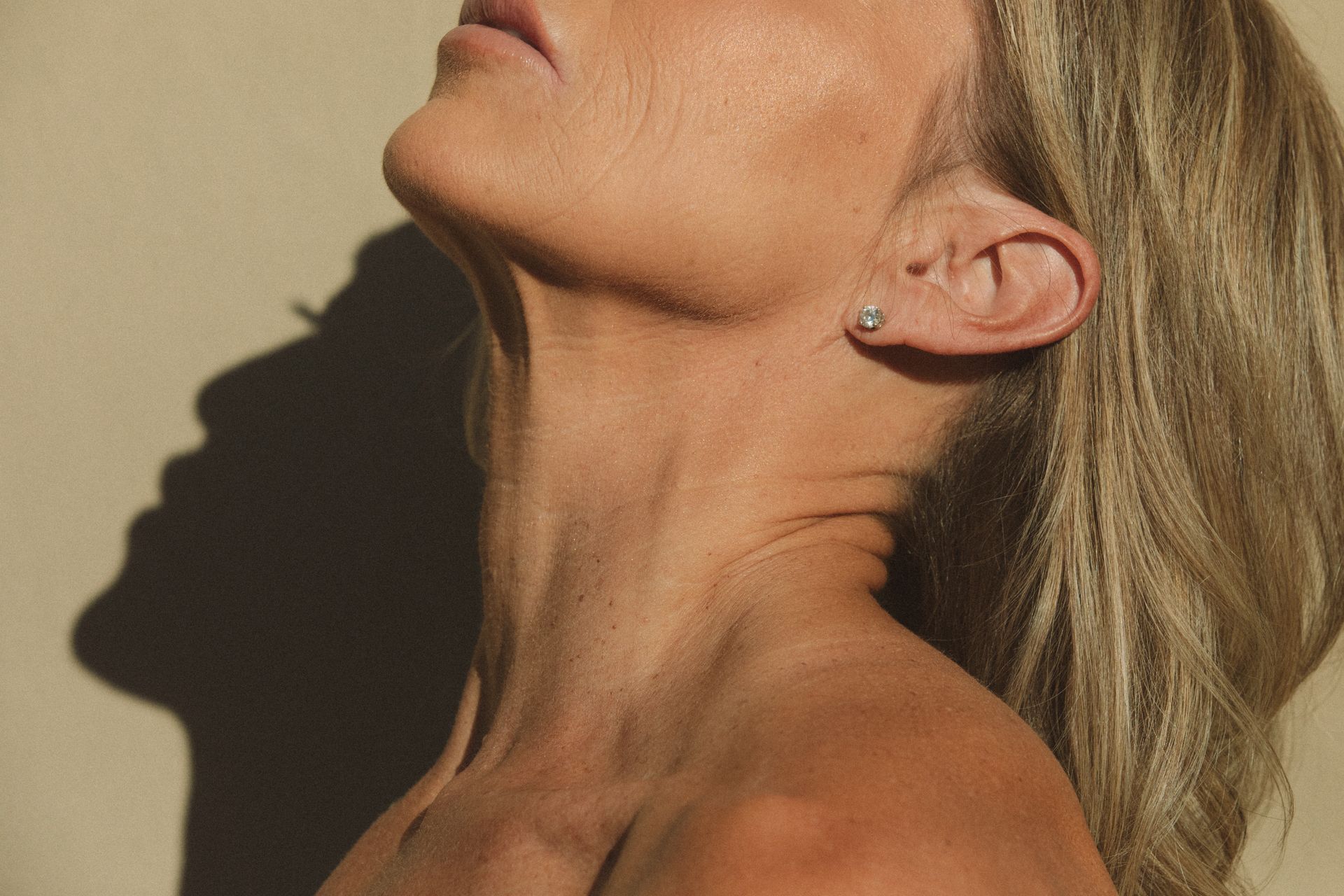 A close up of a woman 's neck and ear with earrings.