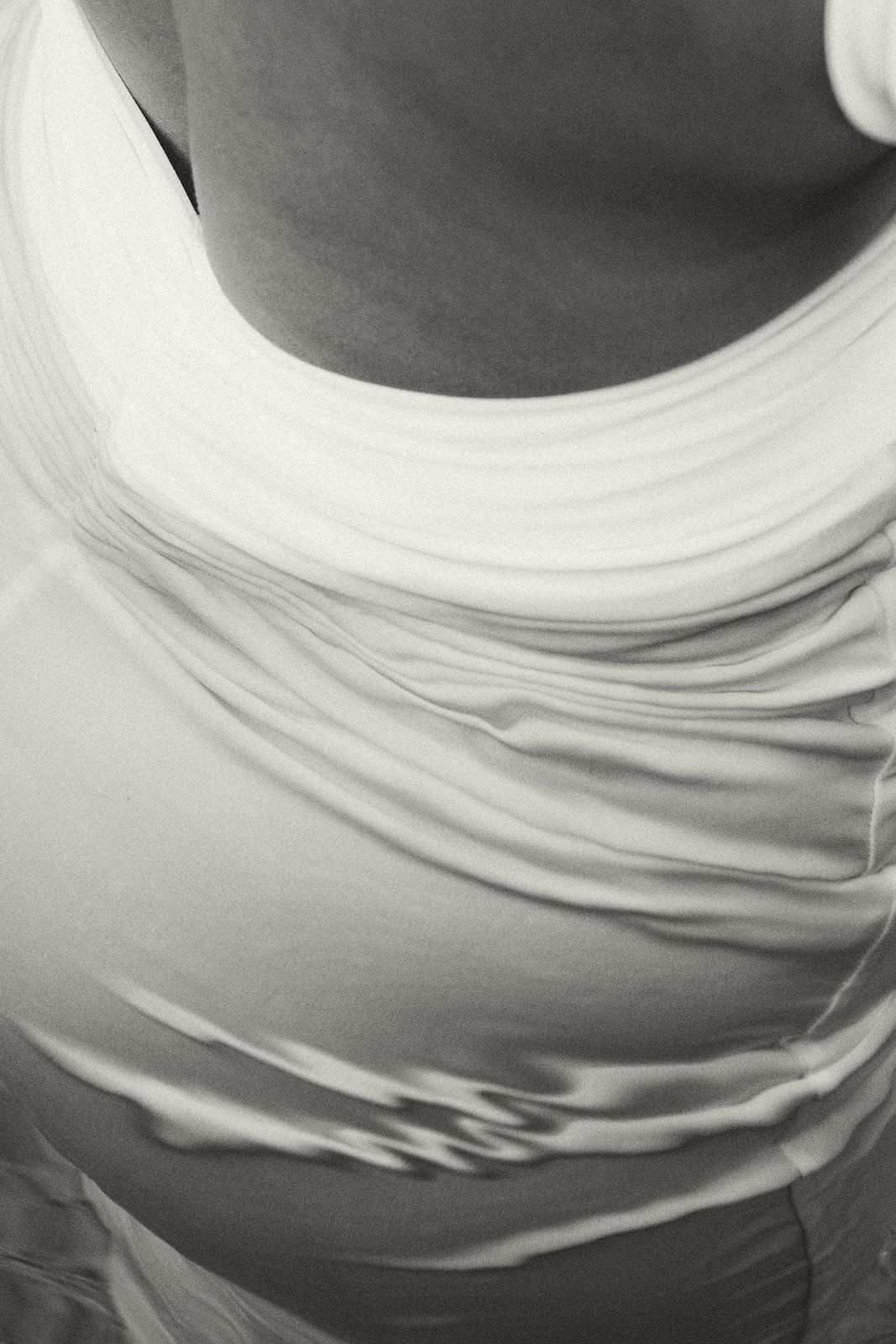 a monochromatic close-up of a woman in a white dress