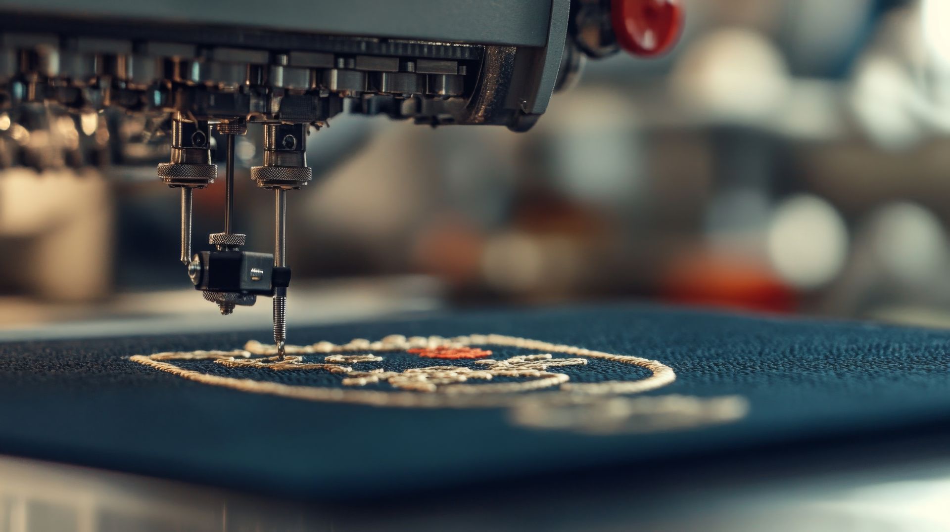 An industrial embroidery machine stitching a white, circular design onto dark fabric.