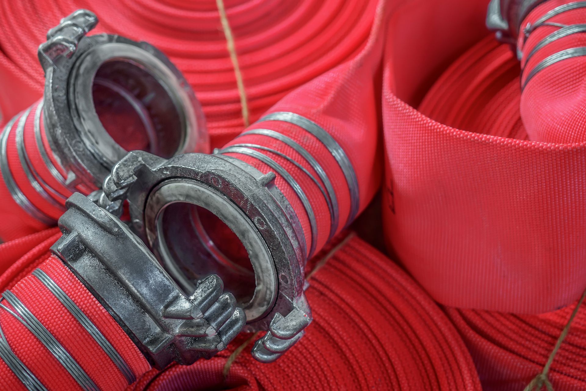 Many twisted red fire hoses.