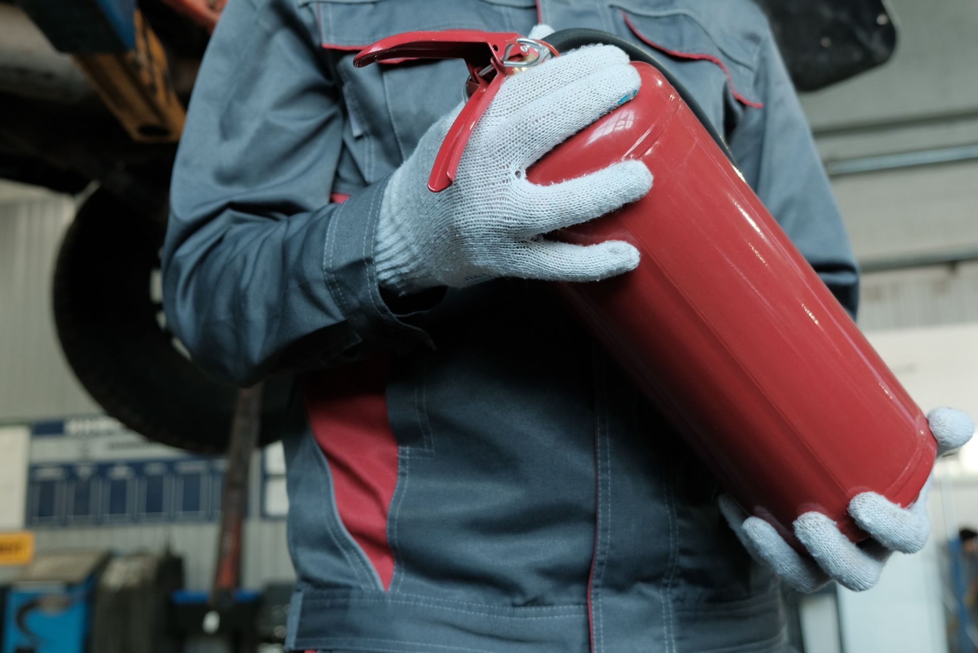 A man in protective gear holds an extinguisher, stressing the need for fire extinguisher recharge.