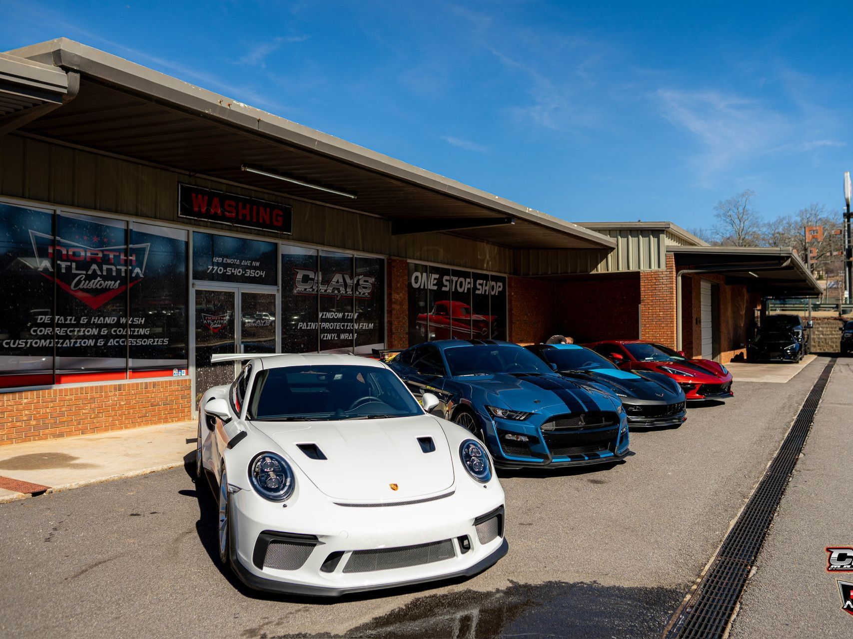 A row of cars are parked in front of a building.