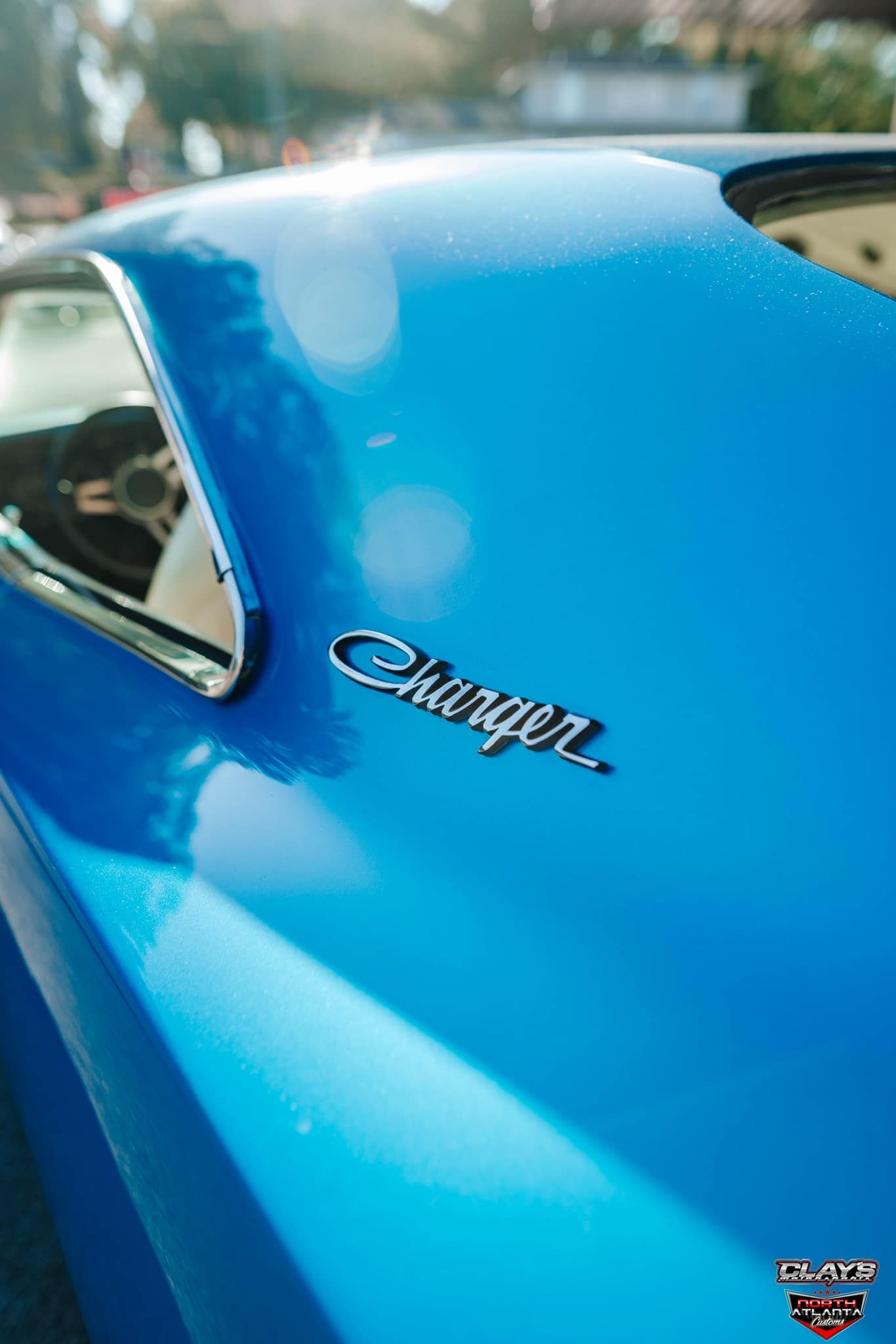 A white mustang with blue stripes is parked in front of a building.