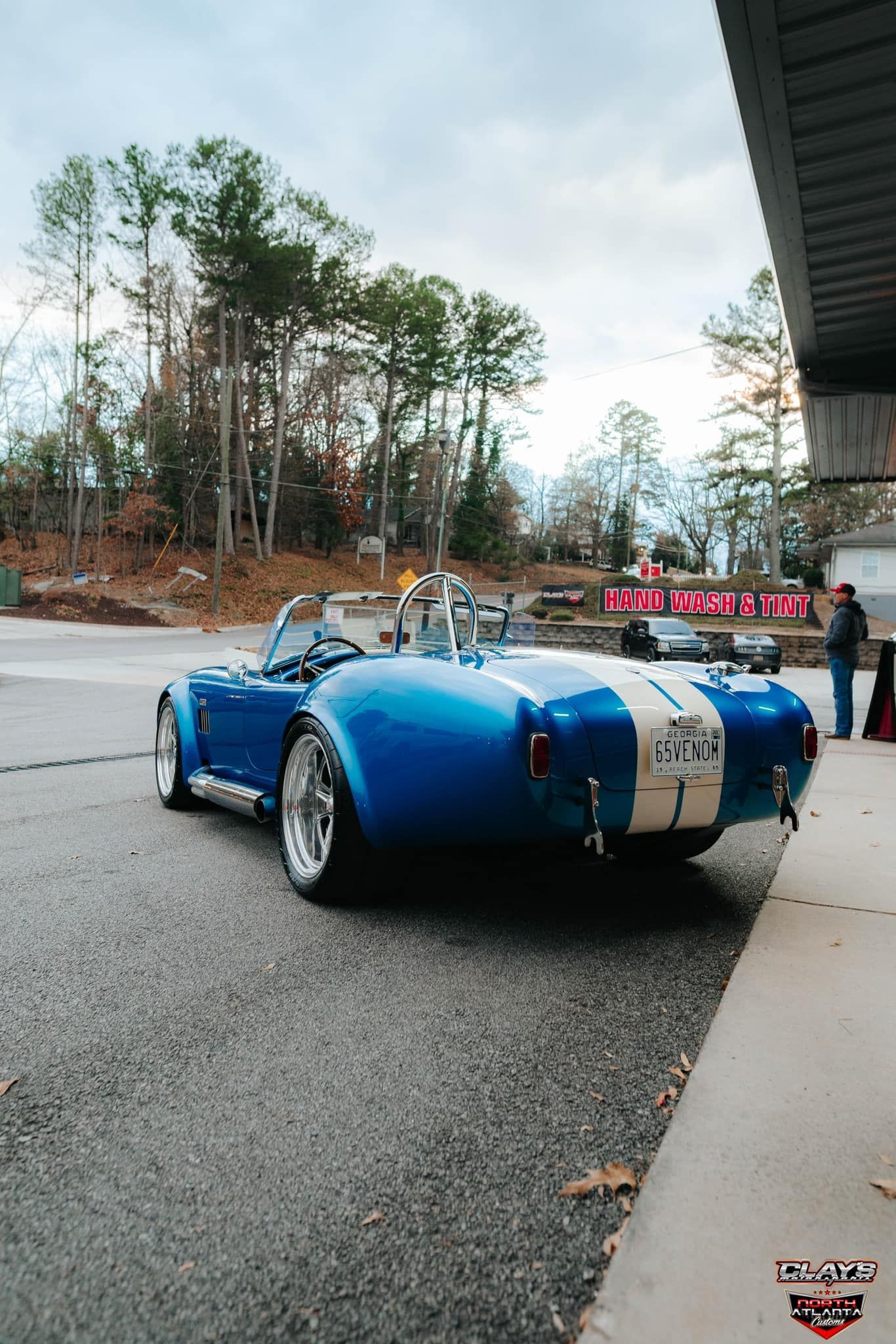 A blue sports car is parked on the side of the road.
