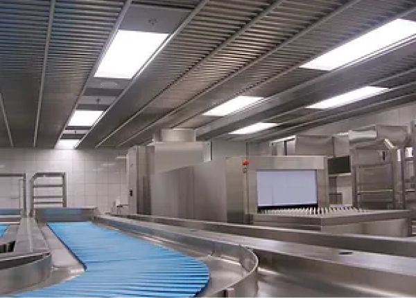 A conveyor belt in a kitchen with stainless steel appliances