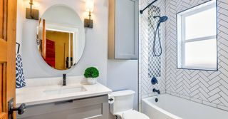 A bathroom with a sink , toilet , shower and mirror.