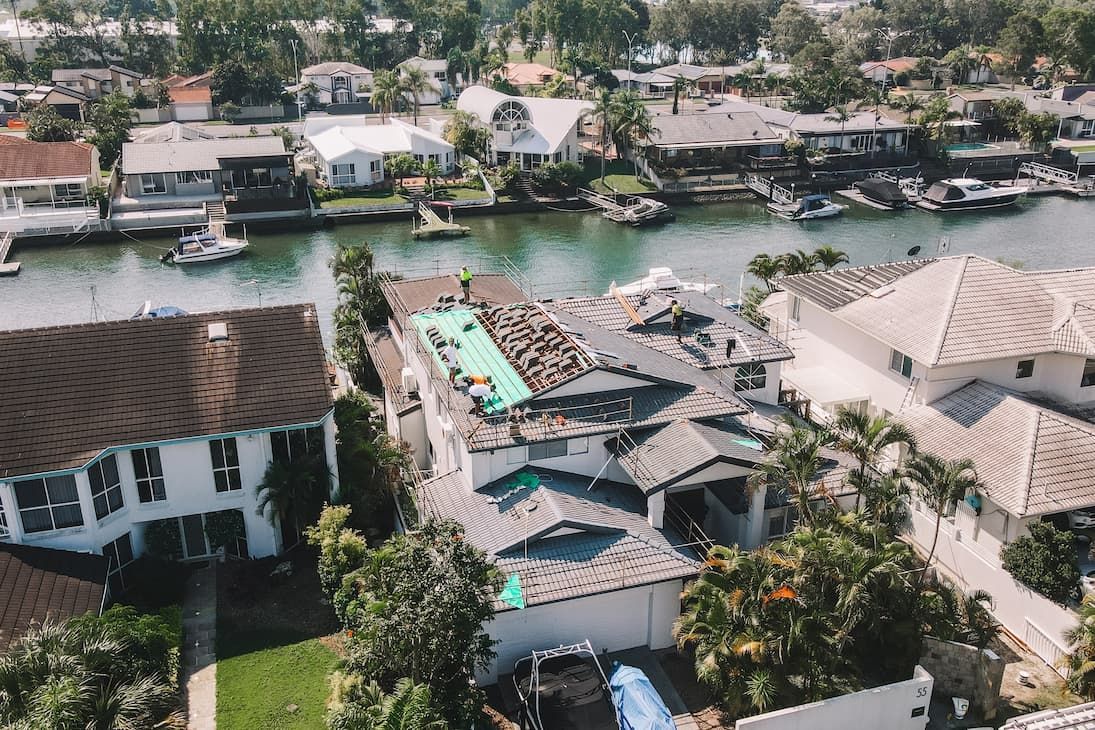 An aerial view of a residential area with a river in the background.