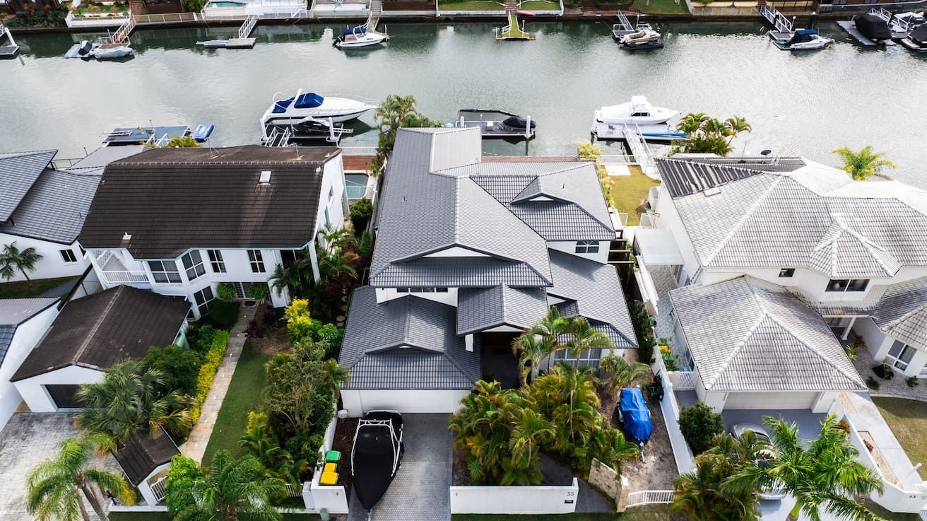 An aerial view of a house next to a body of water.