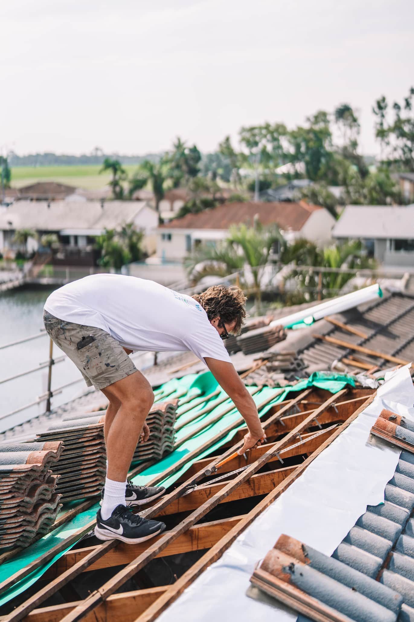 A man is working on the roof of a house.