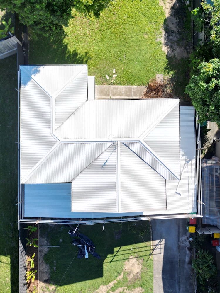 A man is standing on the roof of a house.