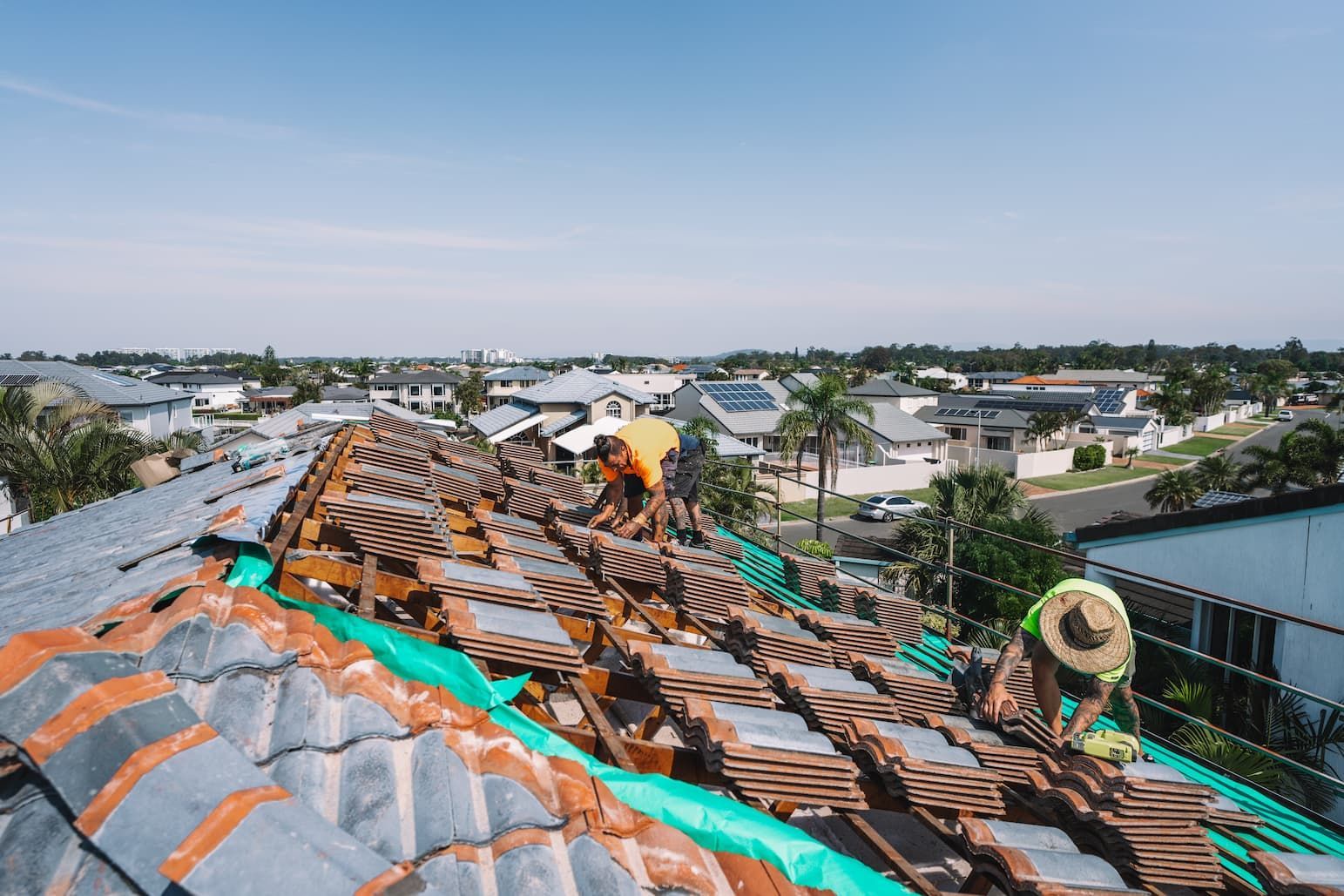 A group of men are working on the roof of a house.