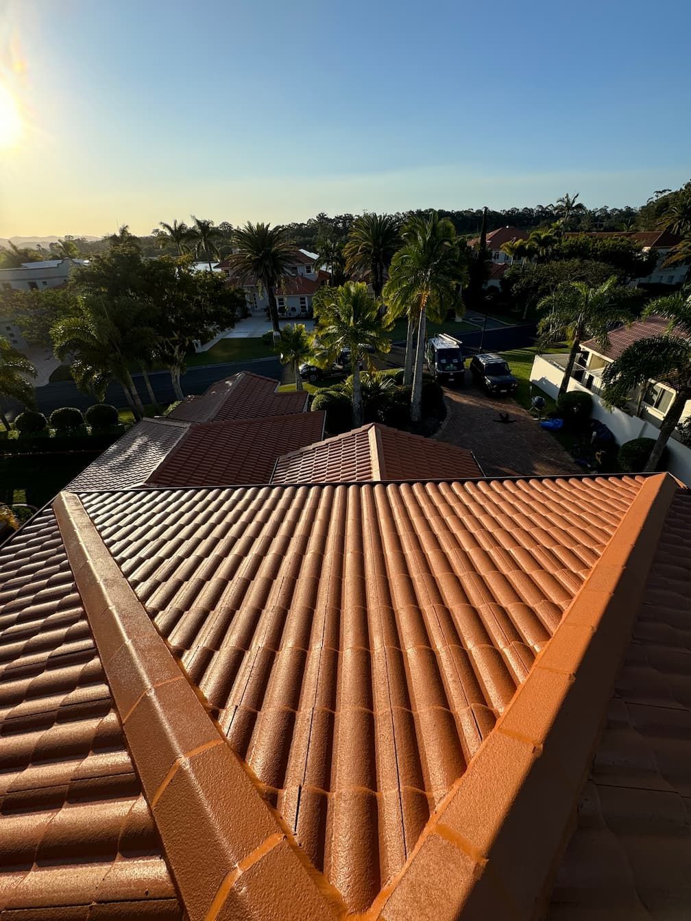 An aerial view of a roof with a sunset in the background.