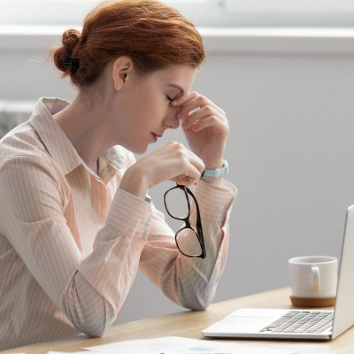 Woman rubbing eyes representing MGD or Meibomian Gland Dysfunction