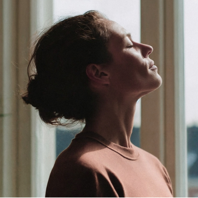 A woman looking up with eyes closed, representing dry eyes worse in the morning or at night