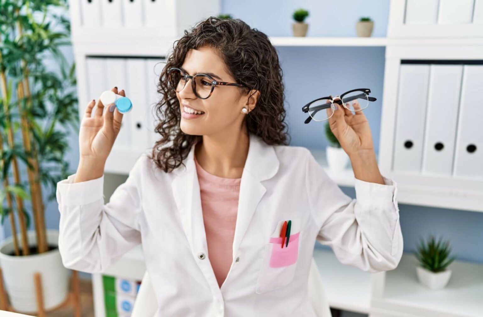 woman holding contact and glasses representing Are Contacts Lenses the Same as Prescription Glasses