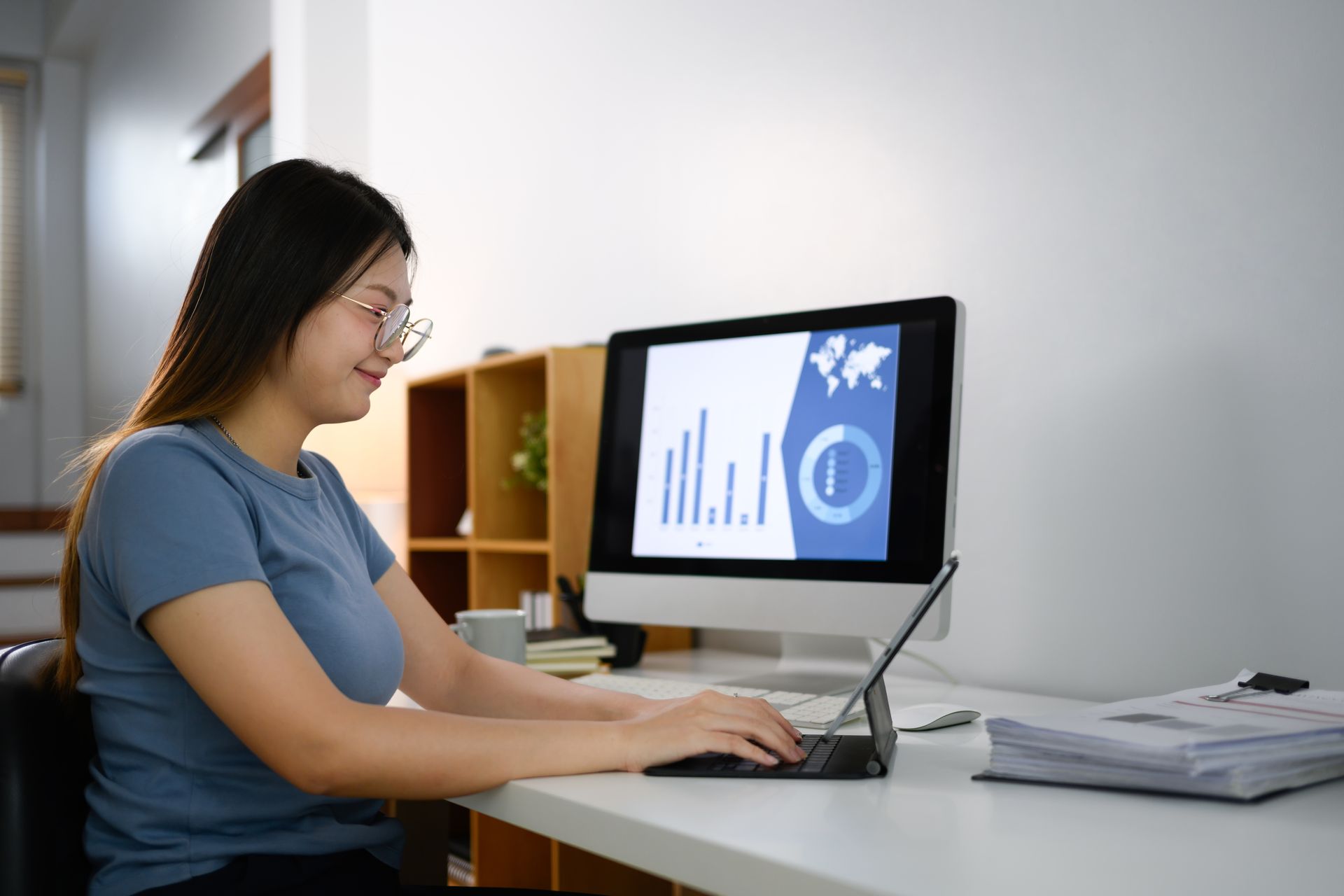 A clinic staff member uses medical billing software on a computer to analyze data and plan for better revenue cycle management.