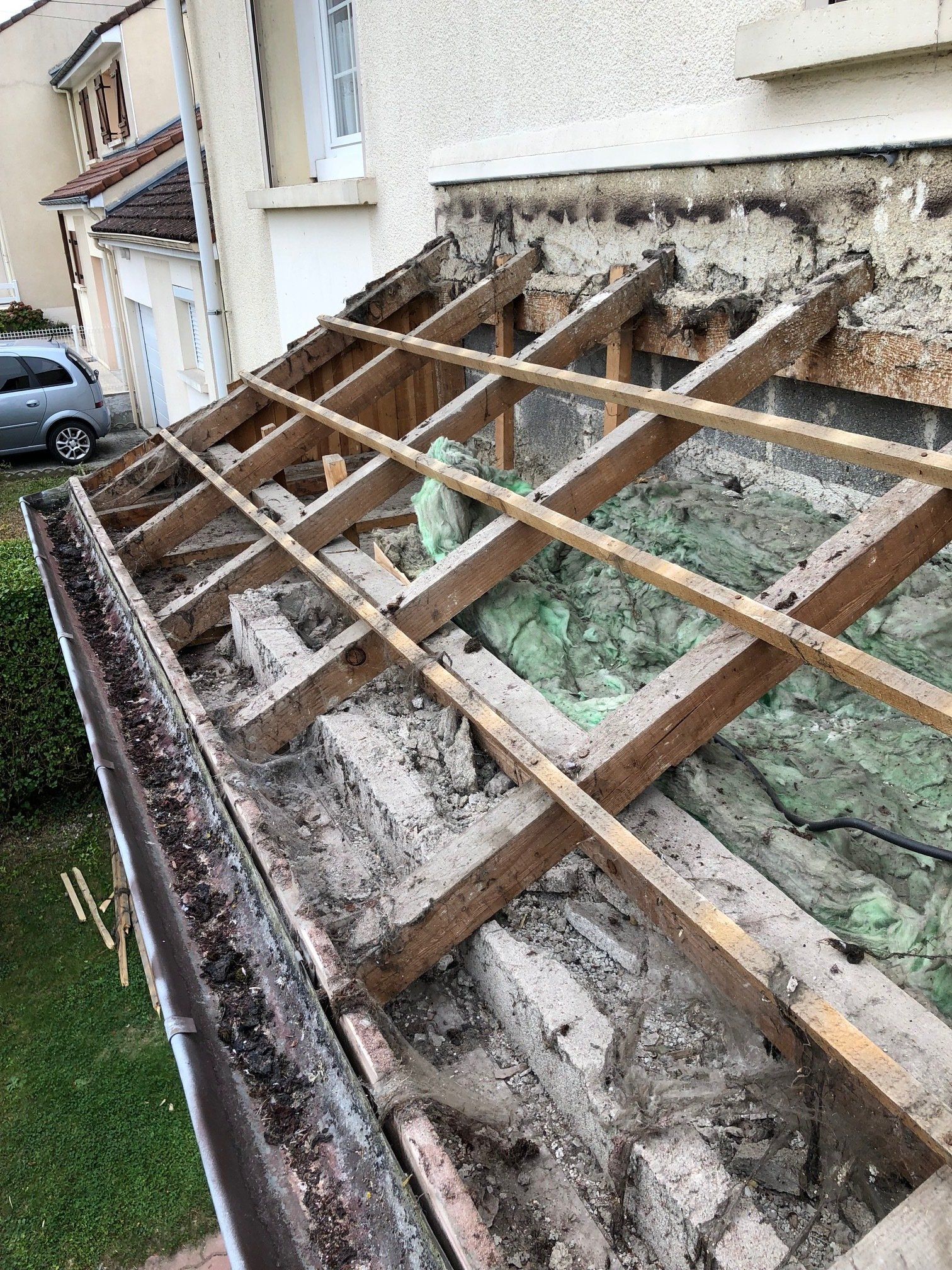 Une charpente en bois est en train d'être retirée d'une maison.