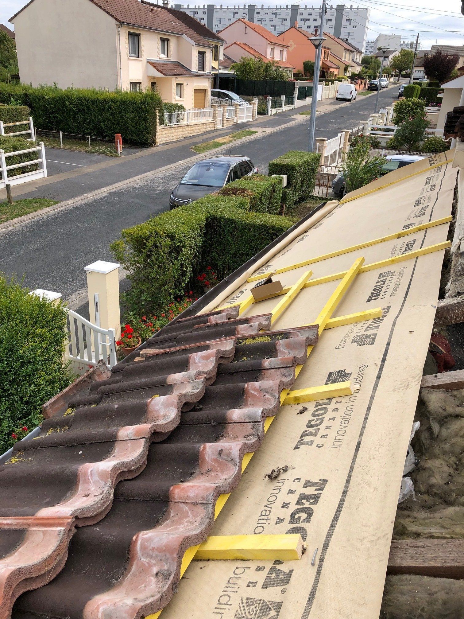 Un toit avec beaucoup de tuiles dessus et une rue en arrière-plan.