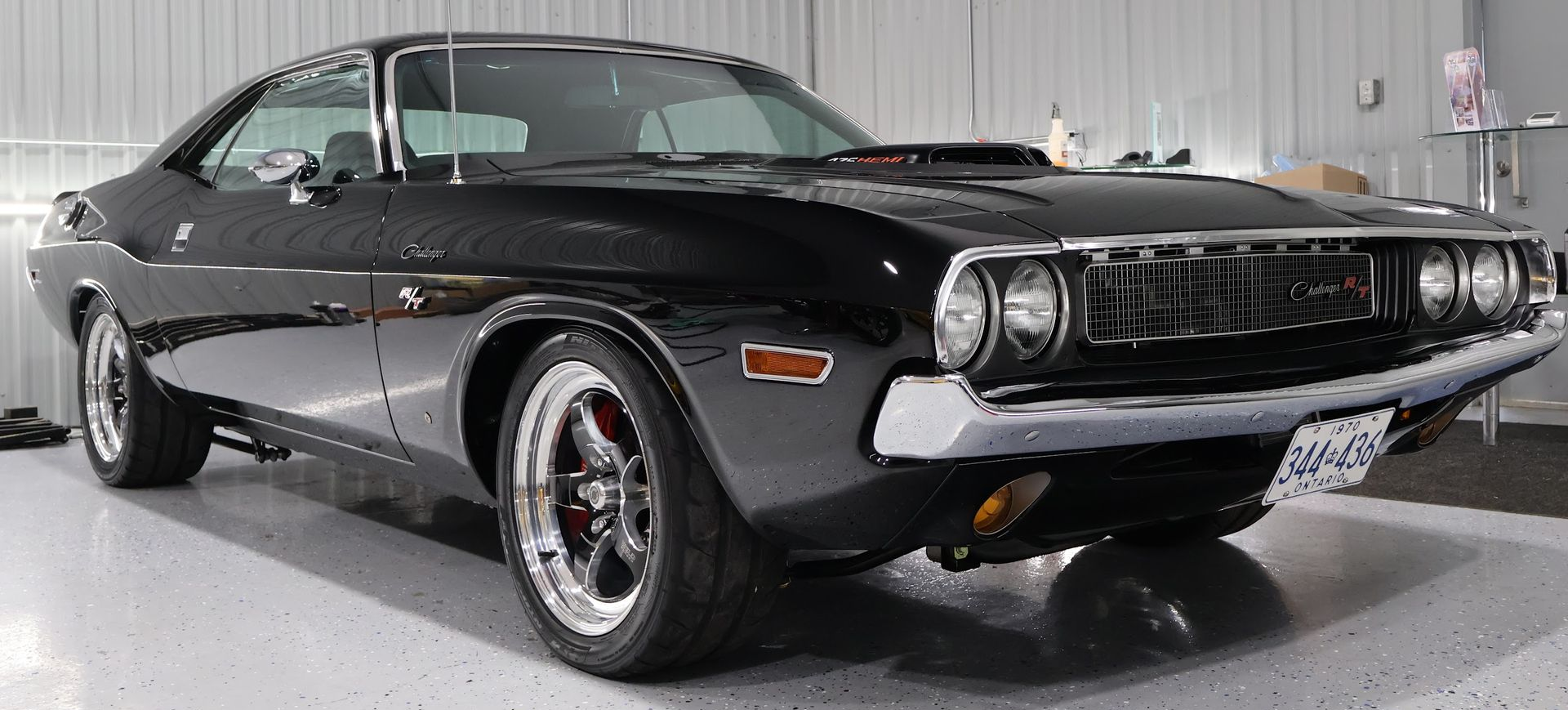 A grayscale front view of a sleek, modern sports car. The car is parked in a garage.