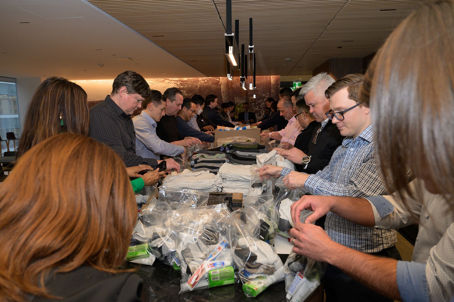 Forklift carrying a tall stack of bottled water on a pallet outdoors.