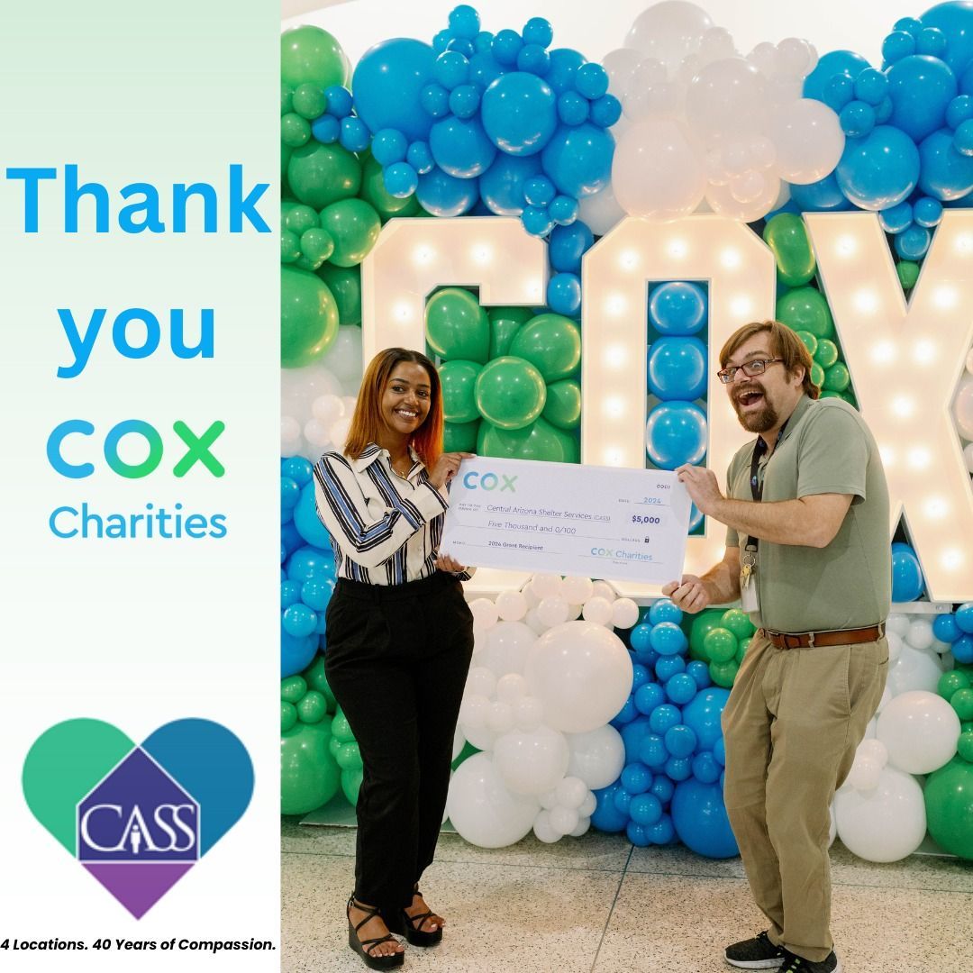 Woman and man holding a check from Cox Charities in front of a balloon backdrop.