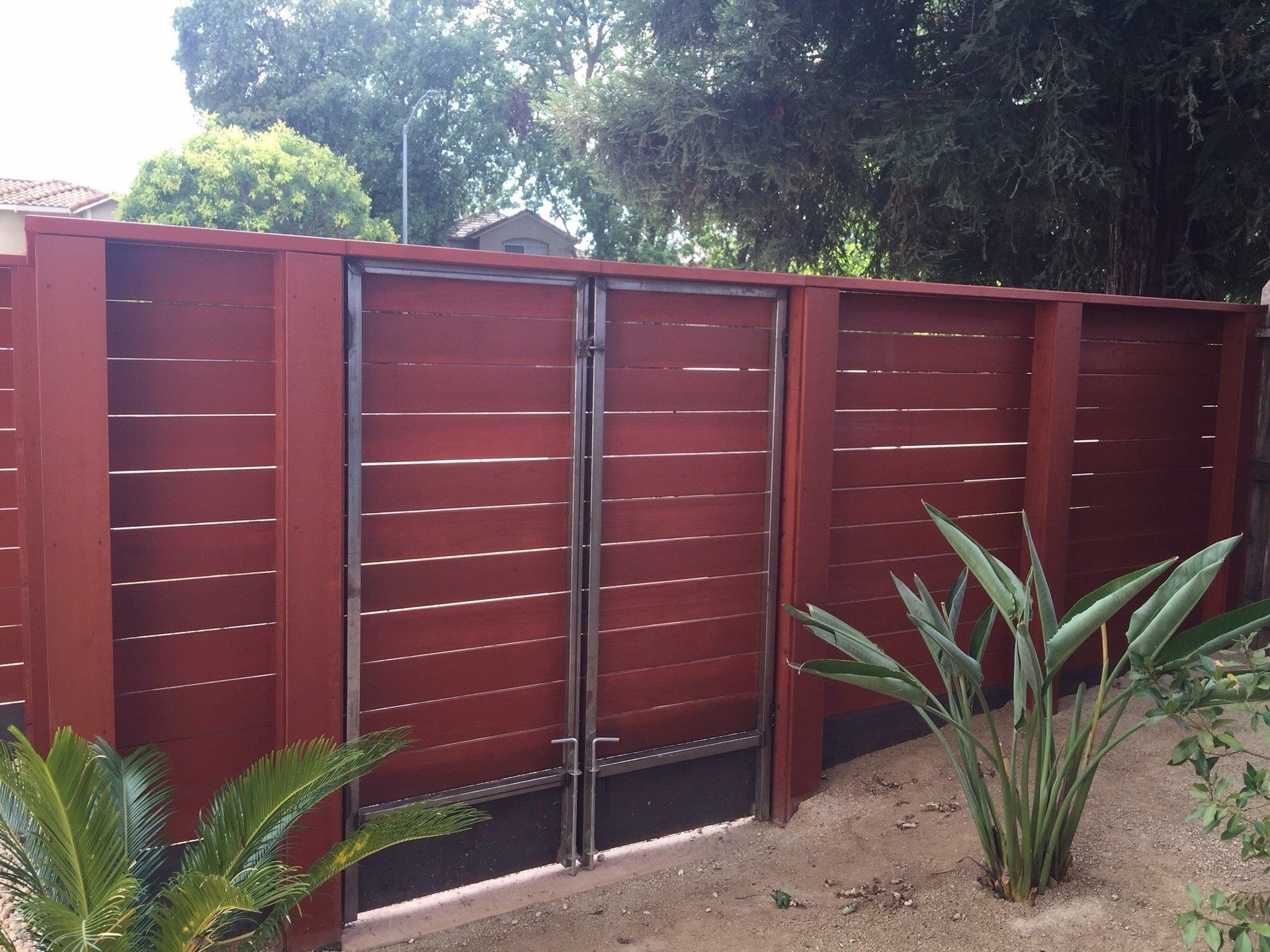 A wooden fence with a gate in the backyard