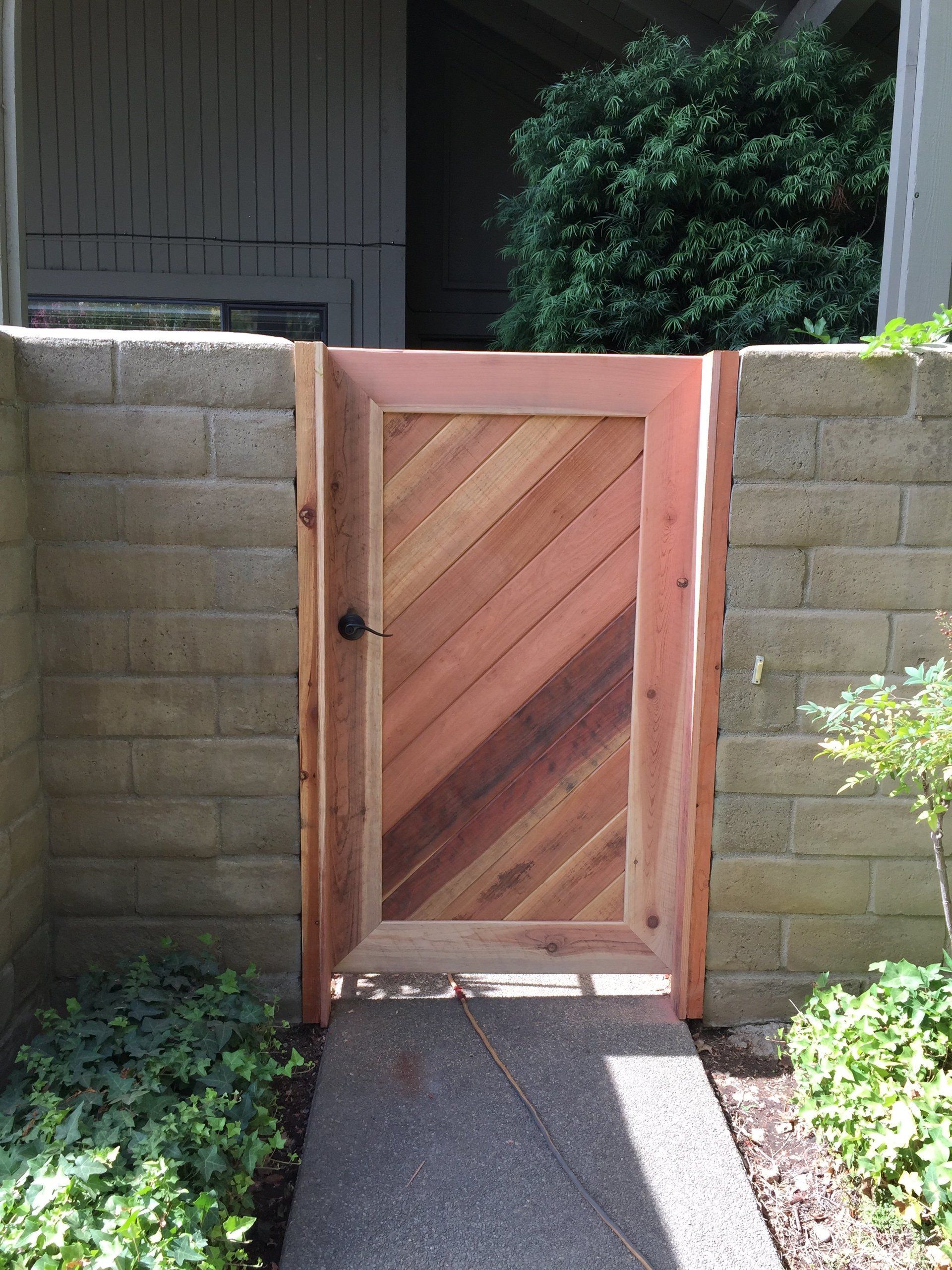 A wooden gate in front of a brick wall