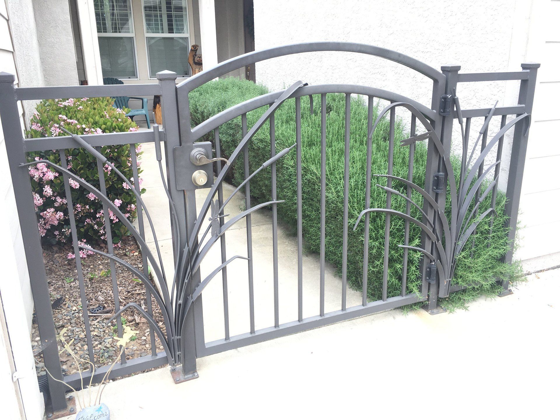 A wrought iron gate is sitting in front of a house.
