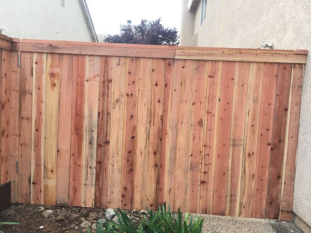 A wooden fence is sitting in front of a house.