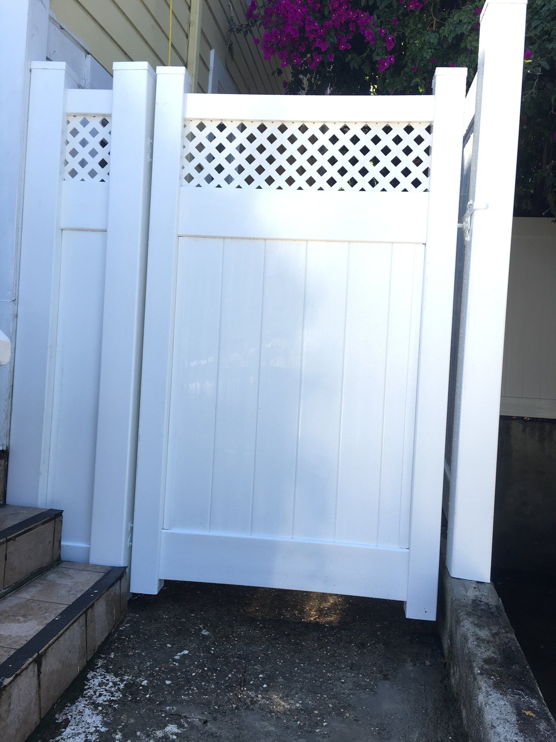 A white fence with a lattice design on it
