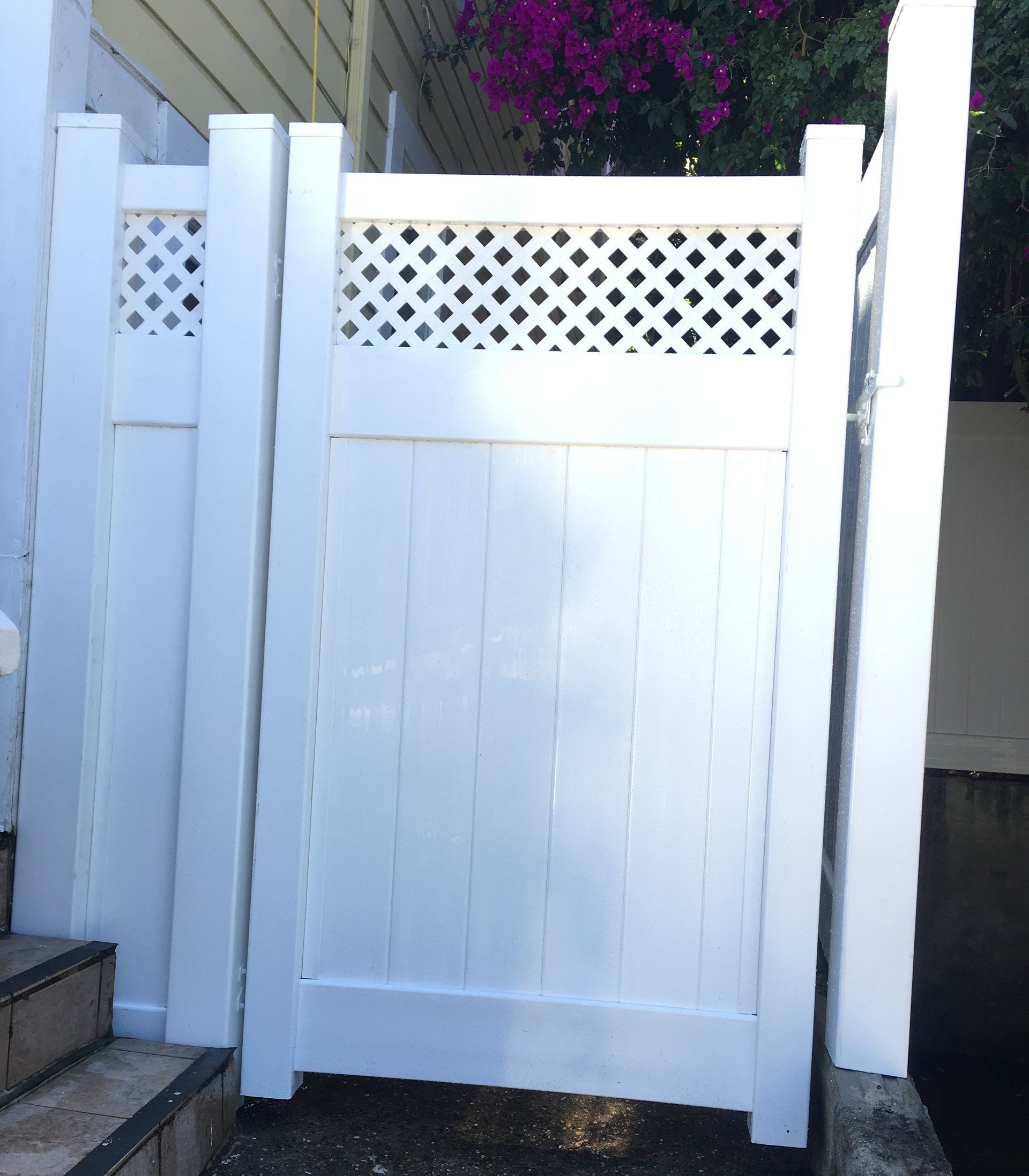 A white fence with purple flowers in the background