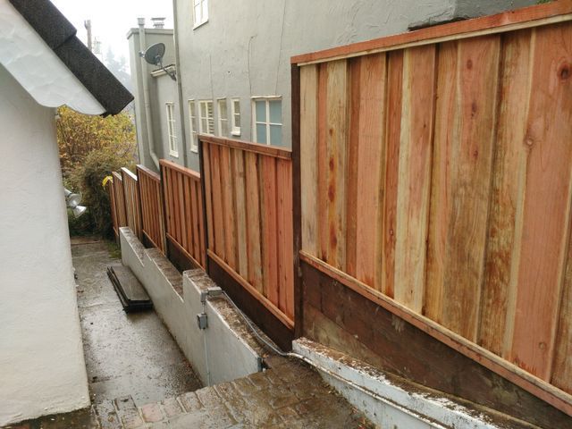 A wooden fence along the side of a building