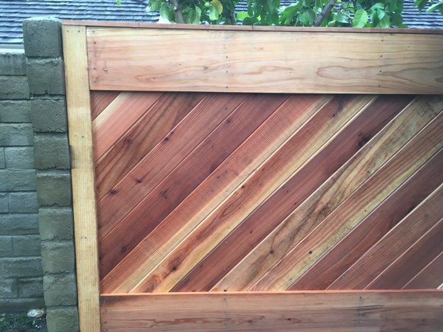 A close up of a wooden fence with a diagonal pattern