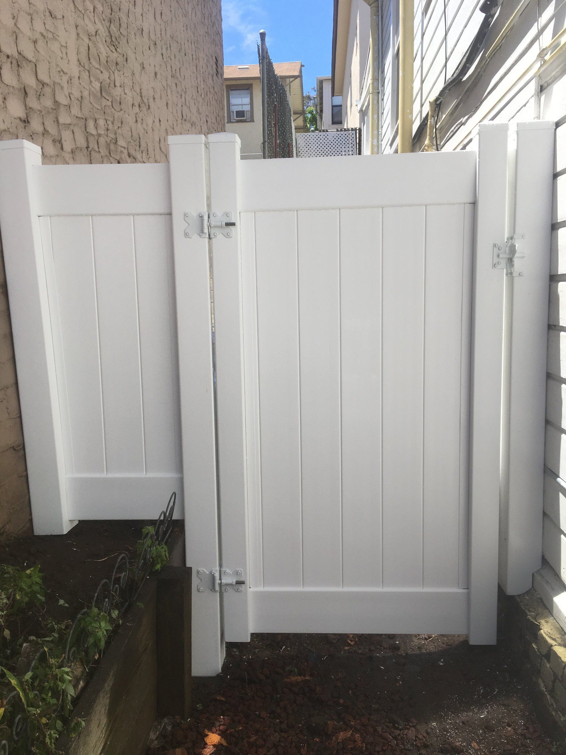 A white fence with a gate in the middle of it.
