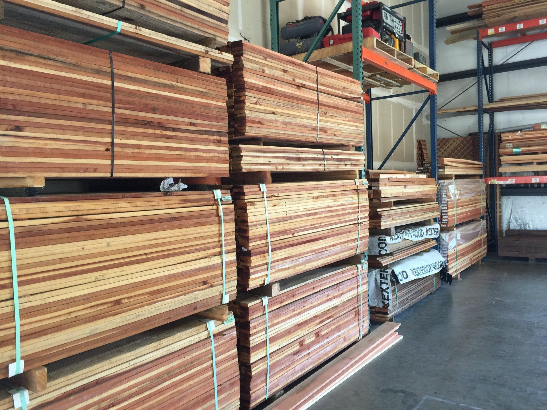 A warehouse filled with lots of wood stacked on top of each other.