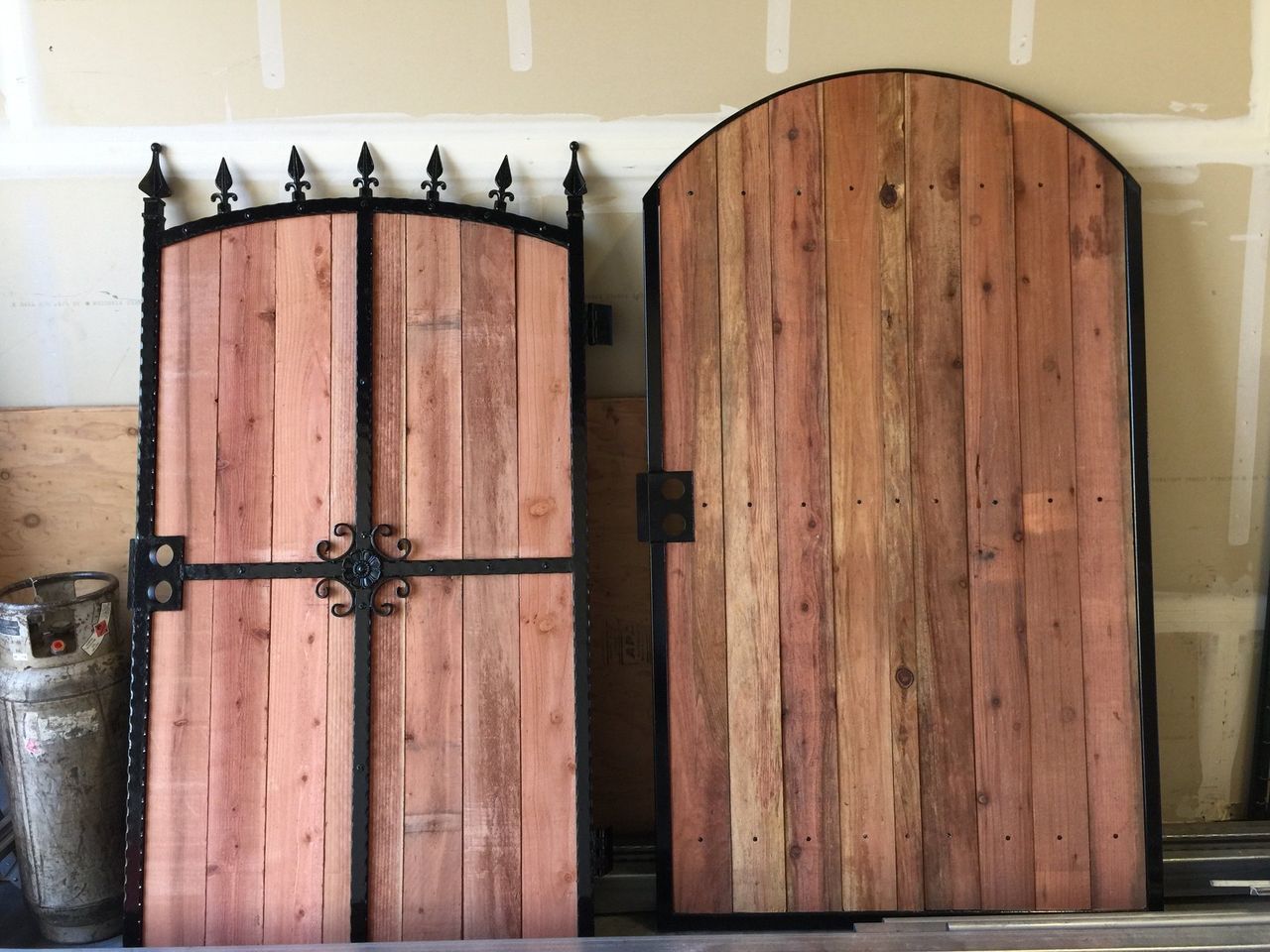 Two wooden gates are sitting next to each other in a garage