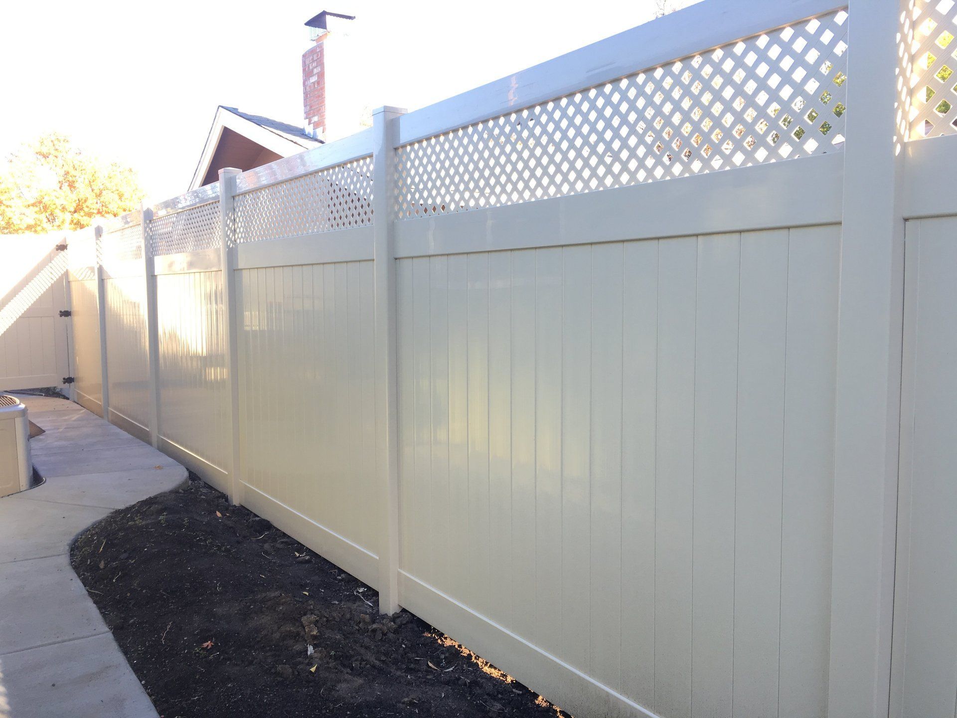 A white fence with a lattice design on the top