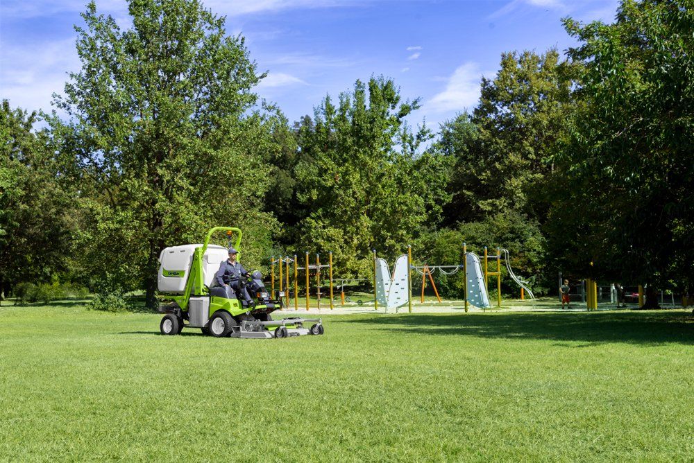 A Person is Riding a Lawn Mower in a Park — Coffs Chainsaw and Mower in Kempsey, NSW