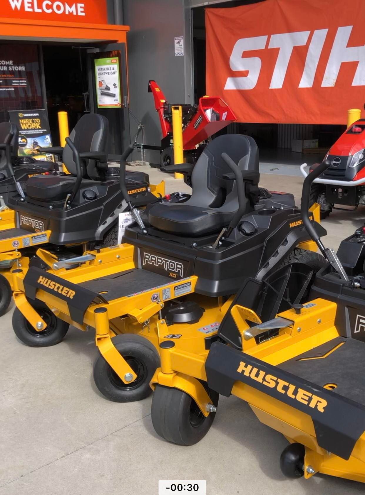 A Row of Yellow Hustler Lawn Mowers Are Parked in Front of a Stihl Sign — Coffs Chainsaw and Mower in Coffs Harbour, NSW