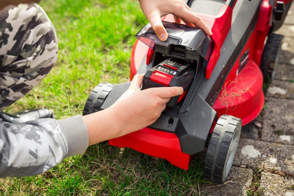 Changing Rechargeable Battery In Electric Lawn Mower — Coffs Chainsaw and Mower in Coffs Harbour, NSW