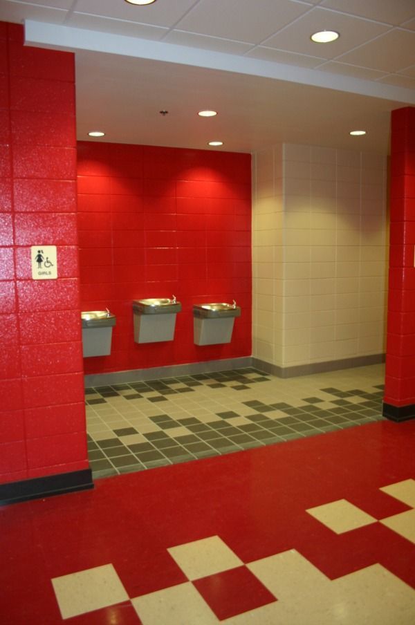 Red and white hallway with water fountains; accessible restroom sign.