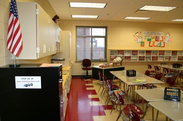 A classroom with desks, cabinets, and an American flag; red and white checkered floor.