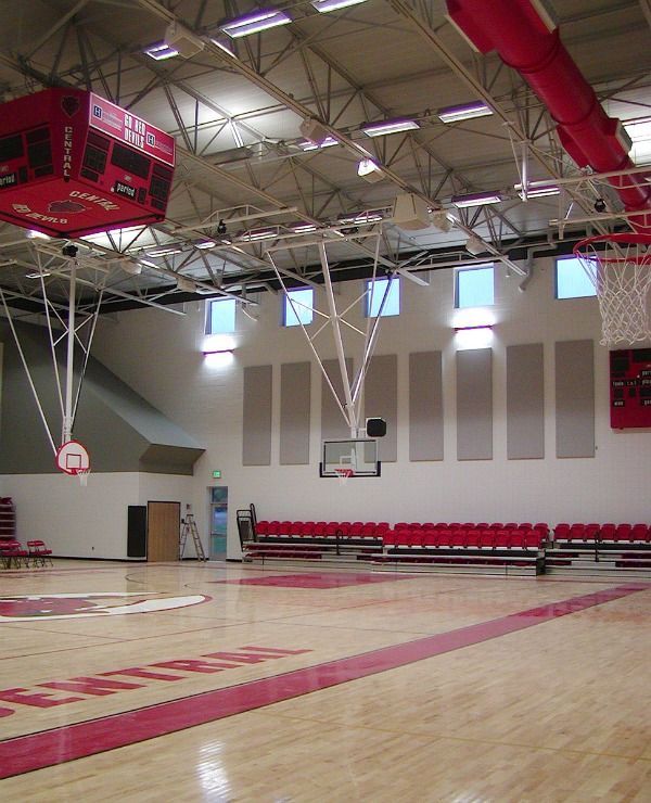 Basketball court with red seating, scoreboard, and hoops; a game setting.
