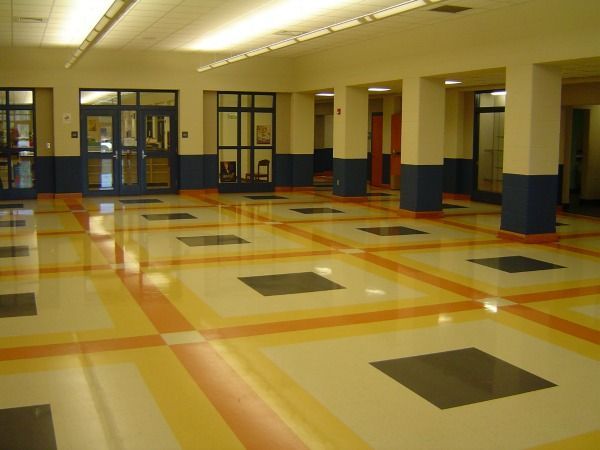 Hallway with colorful tiled floor; blue doors, cream-colored pillars.