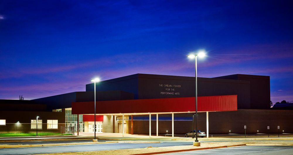 School building at dusk, red awning over entrance, blue sky.