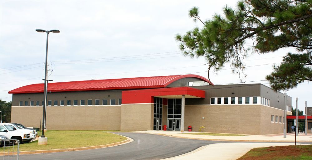 Modern brick building with red accents and roof; exterior shot.