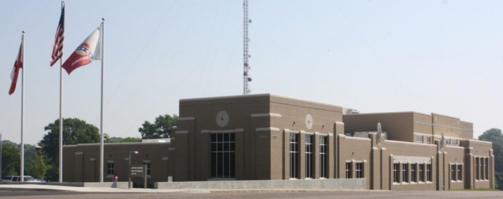 Beige art deco building with flags in front.